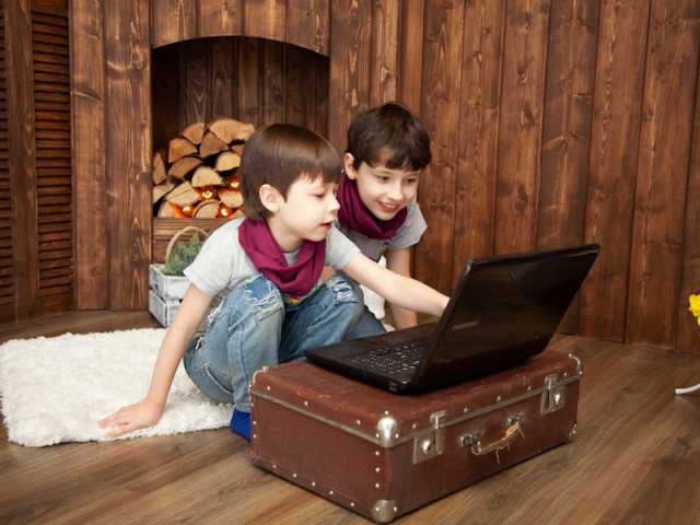 Zwei Kinder sitzen vor einem Laptop 